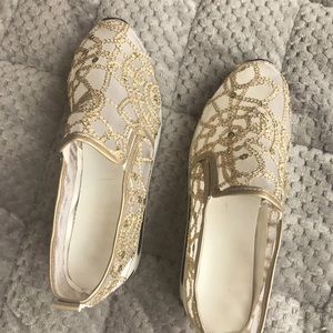Cute gold sequined tennis shoes with lace sides.